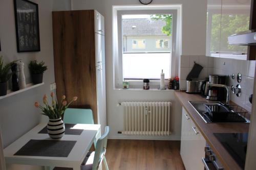 eine kleine Küche mit einem Tisch und einem Fenster in der Unterkunft Ferienwohnung Kassel West in Kassel