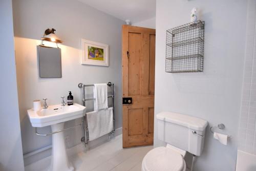 une salle de bain blanche avec un lavabo et des toilettes dans l'établissement Lavender Cottage, à Beer