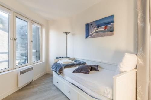 une chambre blanche avec un lit et une fenêtre dans l'établissement Beau studio avec vue mer dans le port de Deauville - Welkeys, à Deauville