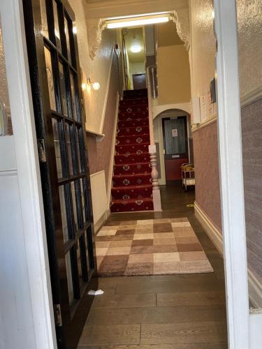 a view of a hallway with a staircase with red chairs at The Stone House Hotel in Blackpool