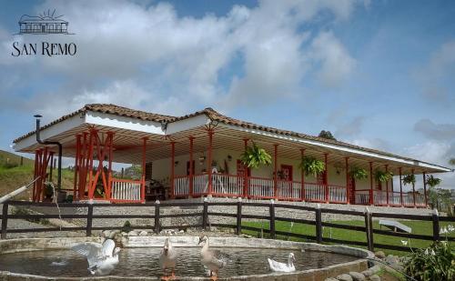 a building with ducks in the water in front of it at Hotel Rural SAN REMO in Santa Rosa de Cabal