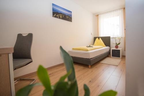 1 dormitorio con 1 cama y 1 silla en Ferienwohnungen und Zimmer Yassi, en Spielberg