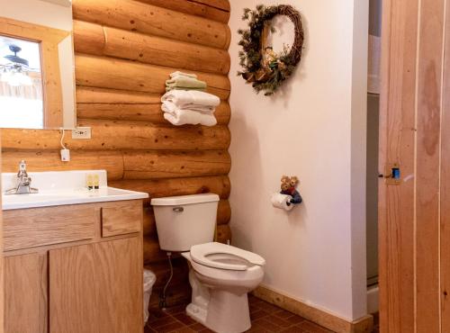 a bathroom with a toilet and a wooden wall at Half Moon Lake Lodge in Pinedale