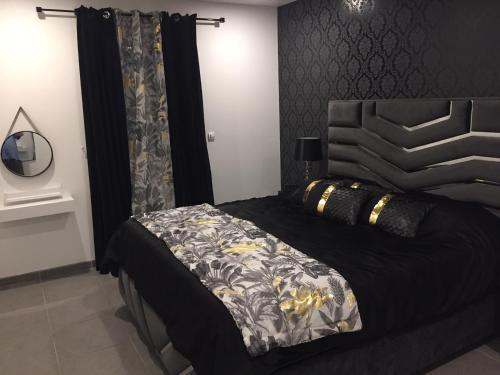 une chambre avec un lit avec une couette noire et blanche dans l'établissement Villa privative 3 chambres et piscine priv près Carcassonne, à Carcassonne