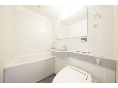 a bathroom with a toilet and a sink and a mirror at R&B HOTEL HACHIOJI - Vacation STAY 38818v in Hachioji