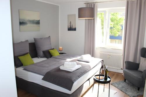 a bedroom with a bed and a chair and a window at Ferienwohnung Kassel West in Kassel