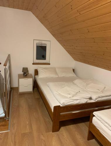 a bed in a room with a wooden ceiling at Domki Jasna Polana in Jastrzębia Góra