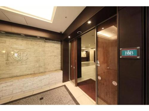 um elevador num edifício com uma placa na parede em R&B HOTEL HACHIOJI - Vacation STAY 38817v em Hachioji