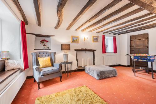 Una sala de estar con una silla y una mesa. en Burrow Cottage, en Kendal