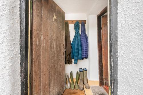 Ein Haufen Schuhe hängen an einer Wand in der Unterkunft Burrow Cottage in Kendal