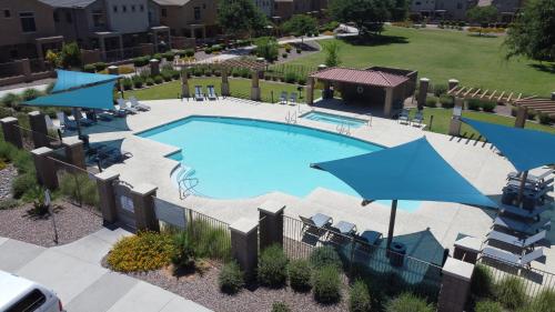 una vista aérea de una piscina con sombrillas azules en LUX! 2 bd 2 ba Farmhouse condo Mesa/Phoenix metro, en Mesa