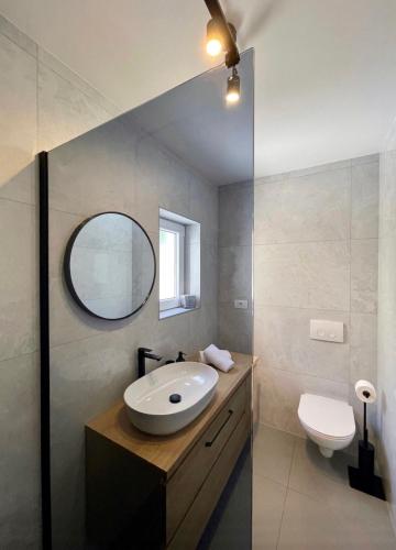 a bathroom with a sink and a toilet at Modern Jacuzzi Apartment Mickey in Dubrovnik