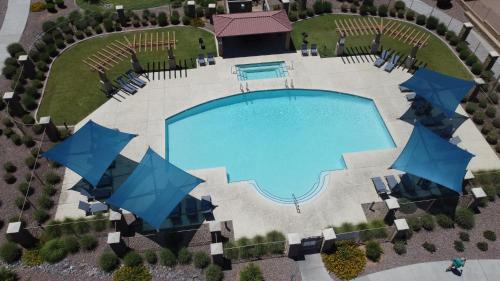 una vista aérea de una piscina con sombrillas azules en LUX! 2 bd 2 ba Farmhouse condo Mesa/Phoenix metro, en Mesa