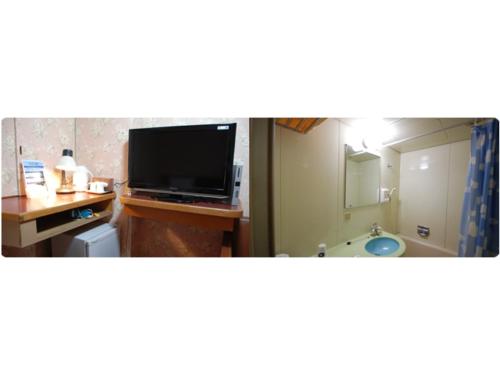 a bathroom with a television and a desk with a sink at Rico Hotel Kokura - Vacation STAY 22584v in Kitakyushu