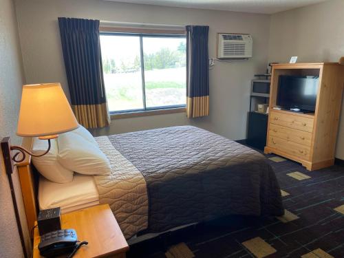 a hotel room with a bed and a television at Walker Hotel in Walker