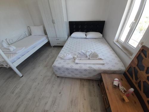 a small room with two beds and a window at ERAY PANSİYON in Gokceada Town
