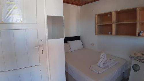 a small white room with a small bed in it at ERAY PANSİYON in Gokceada Town