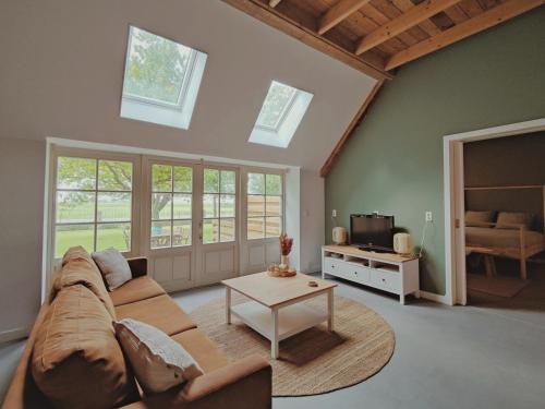 a living room with a couch and a table at B&B Wijdzicht in Wolsum