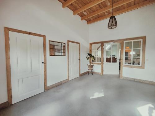 an empty room with a white door and windows at B&B Wijdzicht in Wolsum