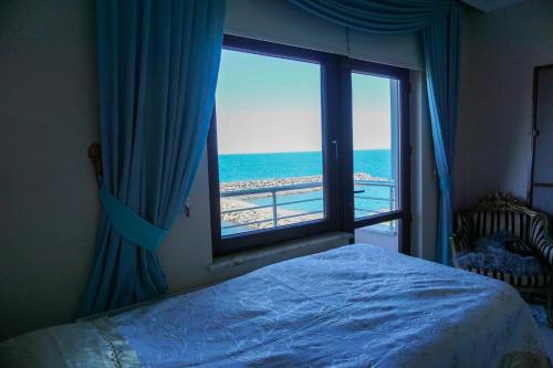 a bedroom with a window with a view of the ocean at Villa Laila Trabzon in Trabzon