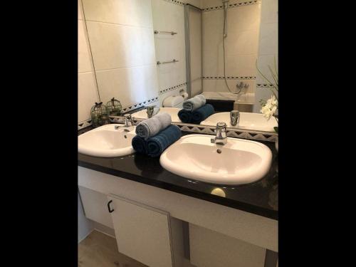 a bathroom with two sinks and a large mirror at Enjoy Durbuy 5 in Durbuy