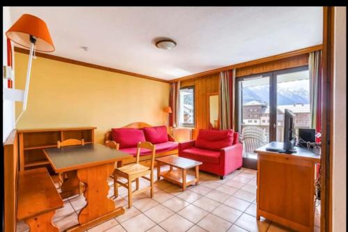 ein Wohnzimmer mit einem Sofa und einem Tisch in der Unterkunft Nice Apt With Wifi Balcon In The Downtown ! in Chamonix-Mont-Blanc