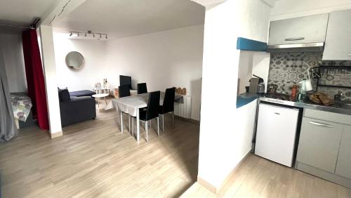 une cuisine et un salon avec une table et des chaises dans l'établissement Logement cosy avec terrasse privée hypercentre, à La Rochelle