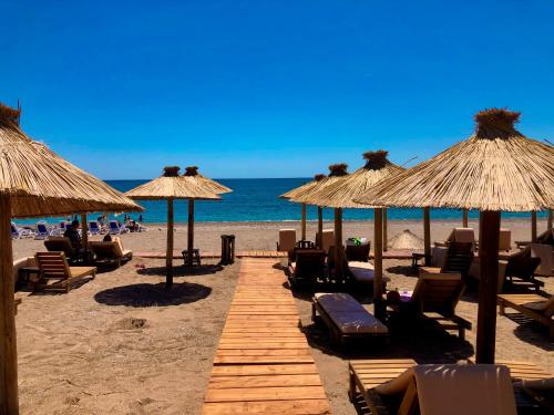 een strand met stoelen en parasols en de oceaan bij Villa Allende in Becici
