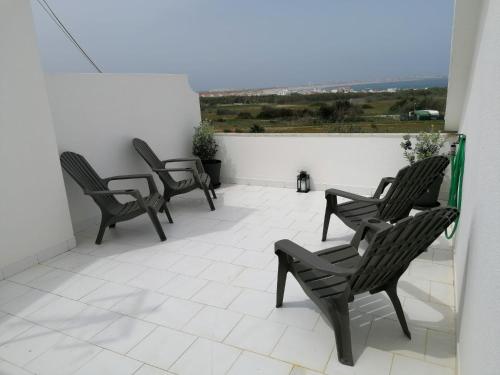 a group of chairs sitting on a balcony at Baleal Atlantic View House in Baleal