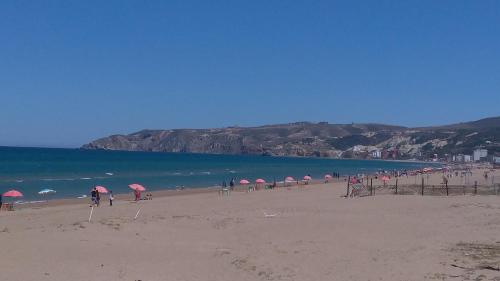 a group of umbrellas on a beach with the ocean at Chez Younès Appartement Marina Saidia Ap8 in Saidia 