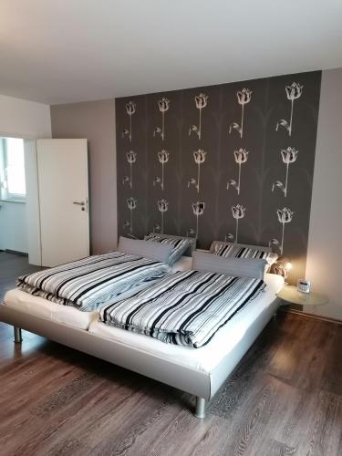 een slaapkamer met een groot bed met een zwarte muur bij Dohlennest, helle moderne Wohnung für 4 Personen in Mülheim an der Ruhr