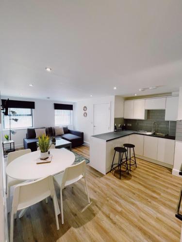 eine Küche und ein Wohnzimmer mit einem weißen Tisch und Stühlen in der Unterkunft Prosper House Apartment 2 in Norwich