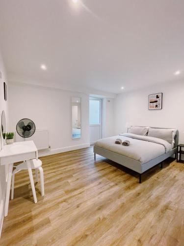 a white bedroom with a bed and a desk at Prosper House Apartment 2 in Norwich