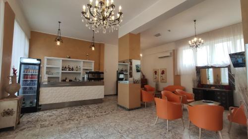 een restaurant met een bar met oranje stoelen en een bar bij Hotel Corona in Rimini