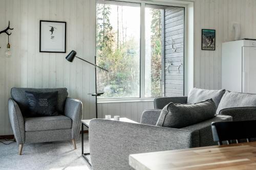 a living room with a couch and two chairs and a window at Villabranten! Ski In - Ski Out, Bike In - Bike Out in Järvsö