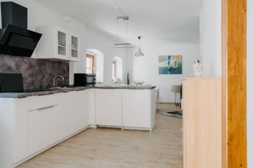 メルビッシュ・アム・ゼーにあるFerienhaus in historischer Hofgasseの白いキッチン(白いキャビネット、シンク付)