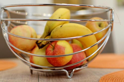 a wire basket of apples and bananas on a table at Haus Gaaden in Gaaden