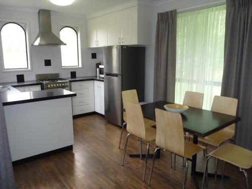 a kitchen and dining room with a table and chairs at Barwon Valley Lodge in Geelong