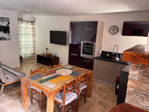 eine Küche und ein Wohnzimmer mit einem Holztisch und Stühlen in der Unterkunft Castagnu in Santo-Pietro-di-Tenda