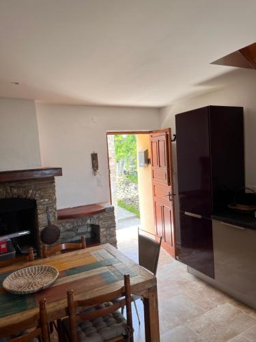 a kitchen and dining room with a table and a refrigerator at Castagnu in Santo-Pietro-di-Tenda