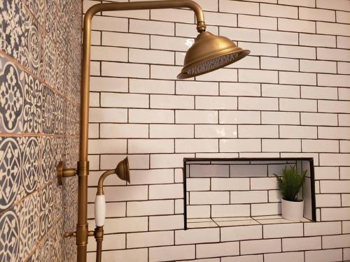 una doccia con una luce in ottone su un muro di mattoni di Cute Cottage-2 min from downtown Lincoln a Lincoln