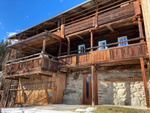 ein großes Holzgebäude mit Balkon in der Unterkunft Berghaus Wiesegg - uriges Tiroler Bauernhaus in Fügenberg