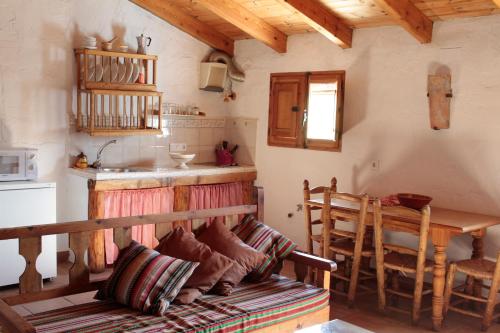 a kitchen with a table and a bench in a room at Cortijo del Cura in Cortijos Nuevos