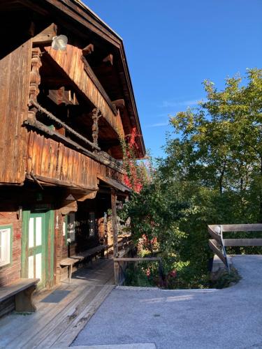 ein altes Holzgebäude mit einer Bank daneben in der Unterkunft Berghaus Wiesegg - uriges Tiroler Bauernhaus in Fügenberg