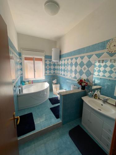 Baño azul con bañera y lavamanos en VILLA ALBA, en Brucoli