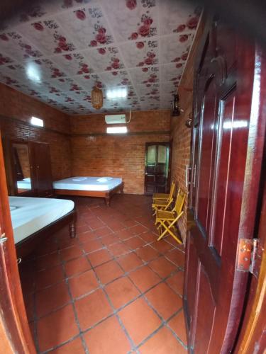 a room with a bed and a table and chairs at Ngoc Phuong Homestay in Vĩnh Long
