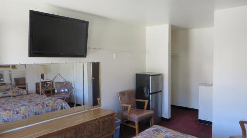 Habitación de hotel con cama y TV de pantalla plana. en Eagle Rock Motel en Los Ángeles