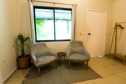 two chairs and a table in a room with a window at Selina Playa Venao in Playa Venao