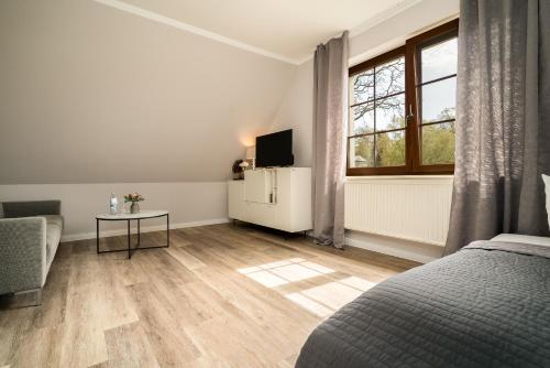 a bedroom with a bed and a table and a window at Residenz am Ostufer in Boek