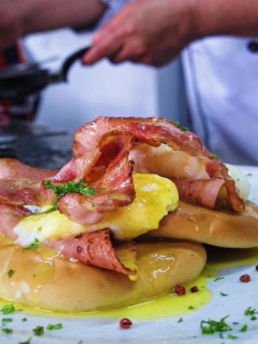 a sandwich with bacon and eggs on a plate at Hotel Campestre San Joaquin in Garzón